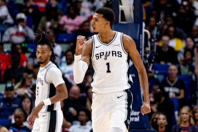 Victor Wembanyama of the San Antonio Spurs is making an early season case for MVP.
The Los Angeles Lakers already are scrambling with injuries to Luka Dončić and LeBron James, among others.
With Cooper Flagg, VJ Edgecombe and Dylan Harper, the rookie class of 2025 is looking strong.
The first week of the 2025-26 NBA season is through and, already, there’s no shortage of compelling story lines at work.
And, thus far, the action has been thrilling — from the double-overtime thriller between the Houston Rockets and the defending champion Oklahoma City Thunder, to Victor Wembanyama’s appointment viewing highlights.
Some teams, however, haven’t quite gotten the starts they wanted. The Rockets, for example, won their first game on Monday, Oct. 27, after dropping a pair of close ones.
But, the season is long, and we’re only getting started.
Here are the winners and losers from Week 1 of the 2025-26 NBA season:
WINNERS
Victor Wembanyama makes early case for MVP
It seems like every night the Spurs play, there’s a new Wemby highlight that pushes the limits of what’s possible on a basketball court. Spurs phenom Victor Wembanyama, still only 21, has seen the offseason work on his body pay off. He bulked up but is moving more fluidly. His jumper is steadier and he’s not afraid to flash his range. He’s getting to the line far more often. And it’s clear he’s on his way to a stretch of defensive dominance for years to come.
He became the first player to score 100 or more points and block 15 or more shots through the first three games of a season. He actually did it with 18 blocks. In fact, heading into the third game of the season, if he alone were a team, he would’ve been tied for sixth in the league in blocks.
More importantly, the Spurs are 4-0.
What championship hangover?
The Thunder have shown no drop off after celebrating their first NBA Finals win since moving to Oklahoma City. And, once again, the Thunder are doing it on defense, leading the NBA in rating, allowing just 104.4 points per 100 possessions. All that, and consider this: the Thunder still are without star forward Jalen Williams, who is recovering from offseason wrist surgery.
The rookie class of 2025
Cooper Flagg got most of the love this offseason, but this is a deep rookie class — and one that already has key contributors. VJ Edgecombe is averaging 25 points through three games for the 76ers. Dylan Harper became the youngest guard in NBA history to post a game of 20 or more points, 5 or more rebounds, 5 or more assists and 0 turnovers.
Kon Knueppel has pitched in for the Hornets and Collin Murray-Boyles dropped 19 points off the bench Monday, Oct. 27 against the Spurs on 7-of-13 shooting.
The Miami Heat are off to the races
Before the season, NBA general managers voted Erik Spoelstra as the best head coach in the NBA. Three games in, he’s showing one of the reasons why. Spoelstra has completely overhauled Miami’s offense, unleashing the post-Jimmy Butler Heat as a transition team. One season after ranking 27th in pace, generating just 97.08 possessions per 48 minutes, Miami leads the NBA (109.67). The Heat are barely setting screens, allowing players to race out in transition, exploiting favorable matchups without letting the defense settle.
Norman Powell (24 points, 7.3 rebounds, 2.7 assists) has been solid, and the Heat should be even better when Tyler Herro (foot) returns. The only question is whether it’s sustainable.
LOSERS
Rocked by gambling scandal, NBA has fans talking about wrong thing
The Rockets-Thunder season opener, as mentioned above, was a classic. Wembanyama is doing things we’ve never seen on a basketball court. Yet, most of the coverage last week focused on the explosive gambling scandals that have implicated current Trail Blazers coach Chauncey Billups and Heat guard Terry Rozier, both of whom were placed on immediate leave.
The league will have to improve its public perception and win back any eroded trust from fans. And — even if they’re cleared following what might be a lengthy legal process — Billups and Rozier might effectively see their careers end just by association.
Lakers already scrambling with injuries
It seemed like Luka Dončić — who averaged 46 points, 11.5 rebounds and 8.5 assists though Los Angeles’ first two games — would be able to shoulder the load while LeBron James (sciatica) recovered. But now Dončić will miss at least a week with finger and leg injuries. The good news for the Lakers is that neither issue appears serious.
But Gabe Vincent suffered a sprained ankle, so Austin Reaves will need to light up box scores for L.A. to remain competitive. That’s only magnified because Jaxson Hayes (knee) and Maxi Kleber (oblique) are banged up in the frontcourt.
The Rockets might have a point guard problem
Adding Kevin Durant made Houston’s offense an elite unit. Losing point guard Fred VanVleet to a torn anterior cruciate ligament showed that the Rockets might not be able to cover up their lack of point guard depth.
Houston has tried Amen Thompson at point guard, and he has looked solid at times. Center Alperen Şengün has brought up the ball at times. Backup Reed Sheppard has done it off the bench, but he’s more of a shoot-first player. Houston has plenty of talent to mask the issue, but they could certainly use a playmaker to feed Durant, Şengün and emerging forward Jabari Smith Jr.
It likely won’t be an issue in the regular season. In the playoffs, however …
The revamped Magic — and their splash addition — sputter out of the gate
Orlando, after adding Desmond Bane to bolster its shooting, was a team expected to make a jump in the wide-open East. So far, however, the Magic haven’t seen any jump at all in their offense. One season after ranking 27th in offensive rating (108.9), the Magic (1-3) are now 25th (108.1). And the same issue from last season — 3-point shooting — persists. The Magic rank 29th in the NBA, converting 3s at just a 29.1% clip.
Bane, a career 40.9% shooter from 3, is converting shots from beyond the arc at just a 27.2% rate.
This post appeared first on USA TODAY